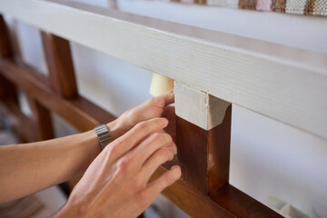 Engage in DIY chair restoration using a paint brush and protective gloves for the process