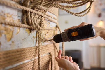A skilled handyman is using a powered drill on a textured wall to enhance home improvement