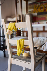 Engage in DIY chair restoration using a paint brush and protective gloves for the process