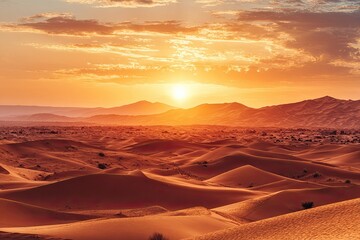Naklejka premium Vast desert landscape at sunrise. Sunrise over dunes, golden hour, mountains in the distance