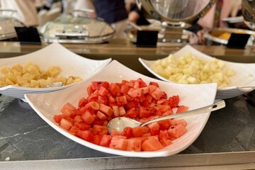 A fruit plate consisting of juicy red watermelon, melon, pineapple, all diced and lying in a beautiful bowl for buffet meals in a restaurant. Fruits on a plate