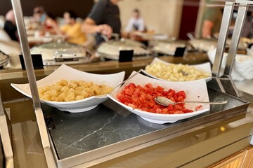 A fruit plate consisting of juicy red watermelon, melon, pineapple, all diced and lying in a beautiful bowl for buffet meals in a restaurant. Fruits on a plate