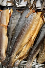 Fototapeta premium Fragment of cold smoked mackerel and Atlantic salmon on a substrate for sale in the supermarket