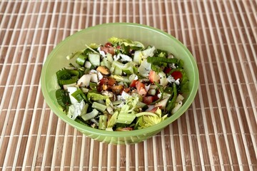 Salad with fresh vegetables like celery, tomatoes, cucumbers, garlic arrows, apples, flax seeds, sesame seeds and sea mussels