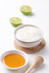 Yogurt, lime and honey on white background