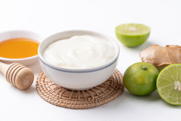 Yogurt, lime, honey and ginger on white background