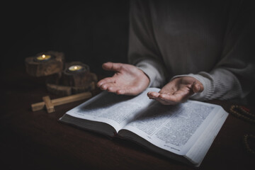 Religious concepts, Woman praying with his hands on a bible.
