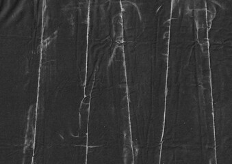 Creased black paper texture background. Monochrome crumpled grunge paper graphic element. Folded surface with abstract lines for overlay design.