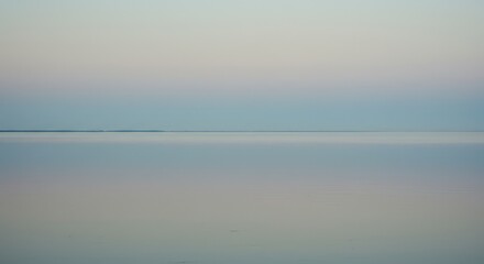 Fototapeta premium Blurred pastel tones of a serene lake at dawn or dusk