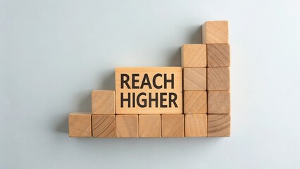 Motivational Wooden Blocks with Text Reach Higher on a Light Background