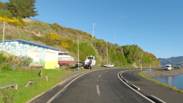 car's pov driving through coastal road along the blue sea in dunedin peninsula, otago, new zealand 4k video