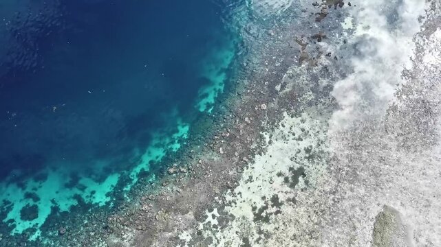 Stunning 4K aerial footage of a coral reef edge meeting the deep blue ocean, showcasing marine biodiversity, coastal beauty, and tropical seascape.