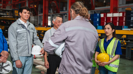 Team engineers and foreman gather for a meeting at the factory machines. Industry workers join together for collaboration and success.