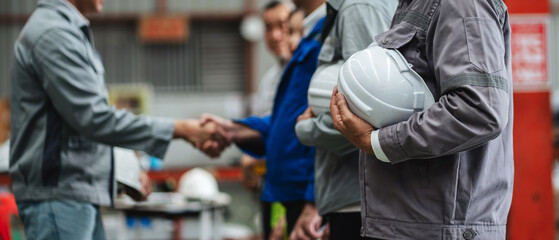 Team engineers and foreman stack hand and shake hands to show success at factory machines. Worker industry join hand for collaboration.