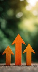 Three orange arrows pointing upwards against a blurred green background