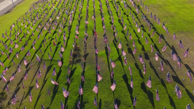 Aerial footage over Waves of mostly USA Flags event as tribute to victims of terror attacks. Patriotic memorial display within picturesque countryside area as seen from above. High quality 4k footage