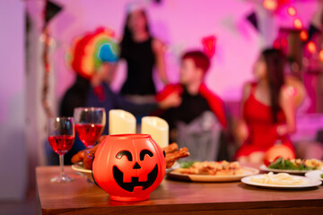 A lively Halloween party table featuring glowing pumpkin decor, festive food, and friends in costumes. celebration, creativity, and the joyful spirit of sharing spooky moments together.