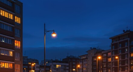 Cityscape at twilight with illuminated apartment buildings and streetlamps