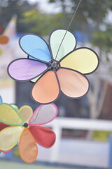 Flower Spinner. Colorful pinwheel in the wind at Garden. Rainbow colored spinner.  Windmill in garden. Simple kinetic environment decor. 