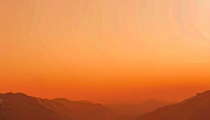 Obraz premium Orange Sunset Over Silhouetted Mountains