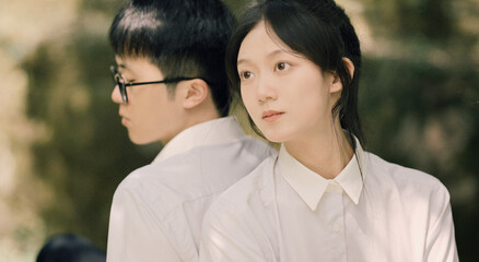 Obraz premium Young adults in white shirts enjoying a serene outdoor moment together.