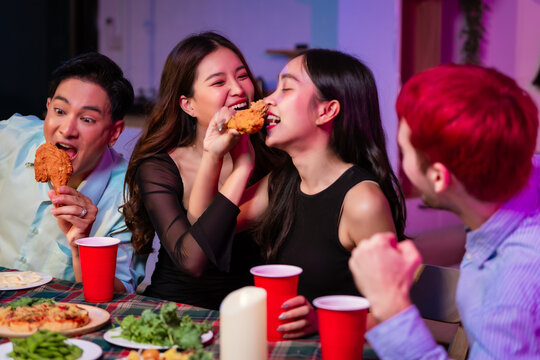 Happy friends celebrate together at home party, clinking wine glasses and sharing delicious food. The joyful moment reflects lifestyle, friendship, laughter, festive celebration in warm and colorful - Powered by Adobe