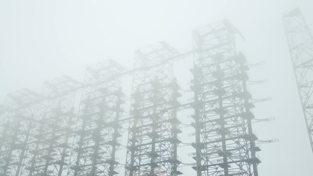 Footage capturing the imposing and mysterious Duga 1 Over the Horizon, OTH radar system, a relic of the Cold War, shrouded in mist within the Chernobyl Exclusion Zone, Ukraine.