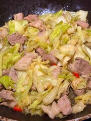 Stir-fried pork belly with cabbage and fish sauce, Thai wok stir-fry, garlicky umami; home-cooking close-up background with copy space