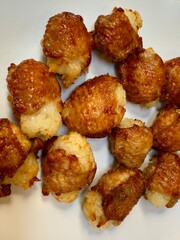 Sticky-rice stuffed chicken bites, golden and crispy from air fryer, Thai snack close-up on white plate, texture background with copy space for banner and menu