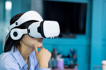 VR headset resting on desk in turquoise office, with pen cups, tech accessories and large monitor
