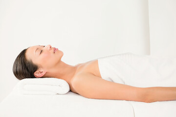 Fototapeta premium Relaxing at spa, serene asian woman resting on massage table with towel pillow