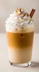 Iced Coffee Beverage with Whipped Cream and Cinnamon on a White Surface