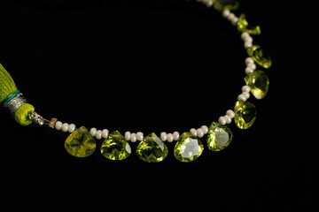 Peridot Faceted Gemstones with Pearls on Black Background