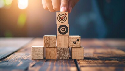 Hand building goal target on wooden blocks with business success.