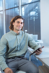 Business professional holding tablet, smiling confidently in modern office setting