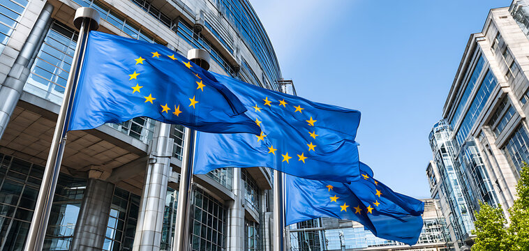 European Union Flags Waving Outside a Modern Building Under Clear Blue Sky During Daylight in a Bustling City - Powered by Adobe