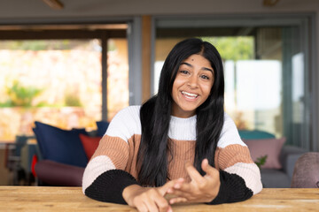 Smiling Indian teenager at home, engaging in conversation with expressive gestures