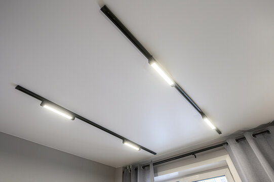 A modern interior view showcasing two track lighting fixtures on a white ceiling