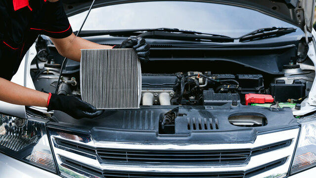Auto mechanic holding car air conditioner filter for check and clean dirty or fix repair heat have engine problem or replace new change air filter of car care maintenance servicing concepts.
