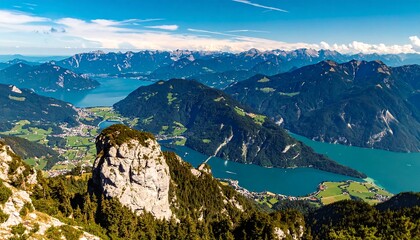 Obraz premium A breathtaking vista of a turquoise lake nestled among towering alpine peaks, showcasing a picturesque valley below.