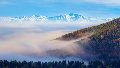 Snow-covered peak surrounded by autumn scenery