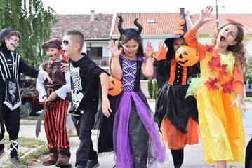 Children on Halloween. Kid walk the street in costumes and collect sweets