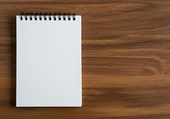 A clean, blank spiral notebook with white pages, lying on a polished wooden desk surface