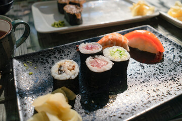 Premium quality sushi featuring fresh salmon, tuna and eel, professionally arranged with Japanese cuisine ambiance in background.