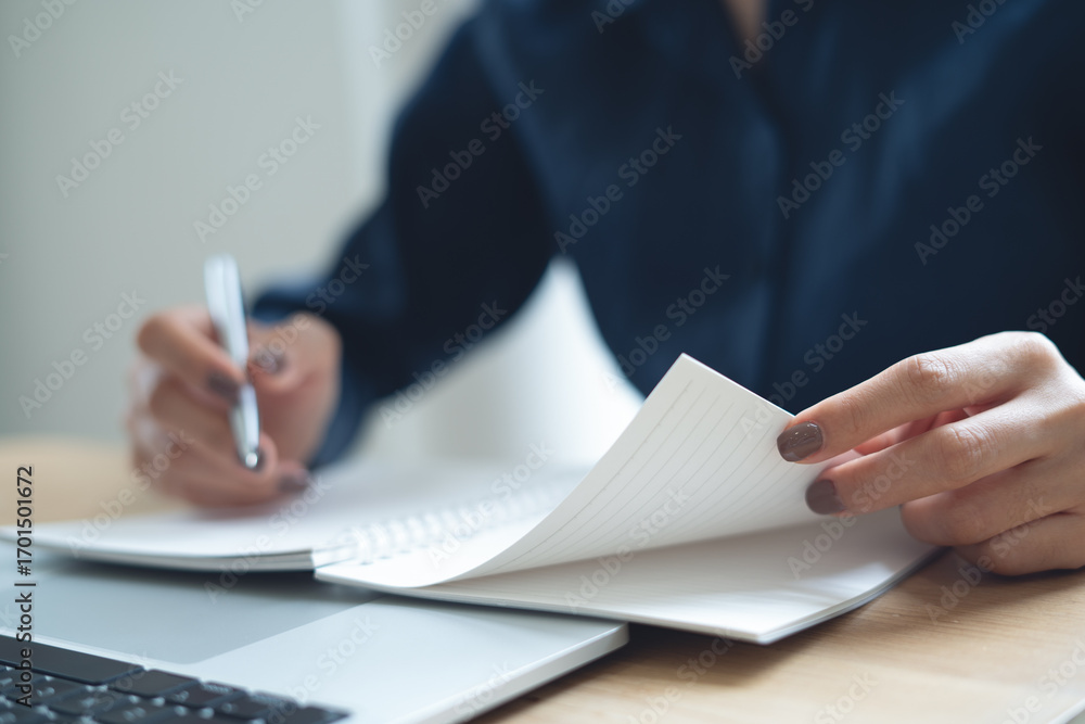 Aufkleber close up of business woman hand writing on notebook at office with laptop computer on table. student