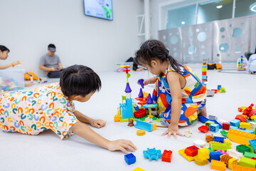 Kindergarten kids little boy and girl enjoy play toy block building