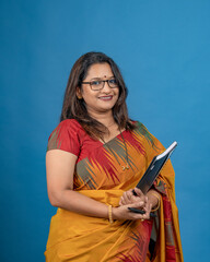 Smiling Indian Woman Teacher Holding Notebook and Pen