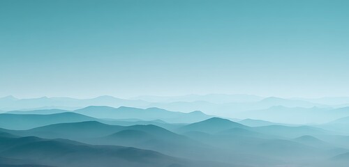 Fototapeta premium Distant mountain range fading into blue haze with soft rolling foothills