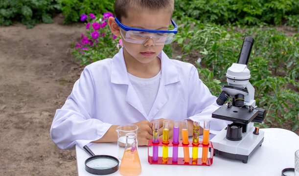 Boy conducting science experiments. Child with microscope
