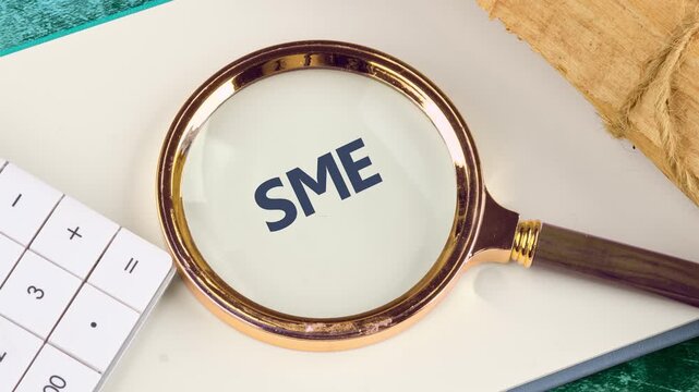 Small and medium-sized enterprises - commercial enterprises. Animation of the SME concept phrase through a magnifying glass